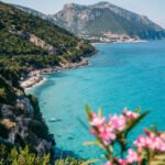 Cala Gonone kan skimtes i horisonten fra stranden Cala Fuili