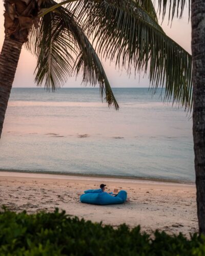 Alex arbejder på computer i strandkanten på Koh Samui