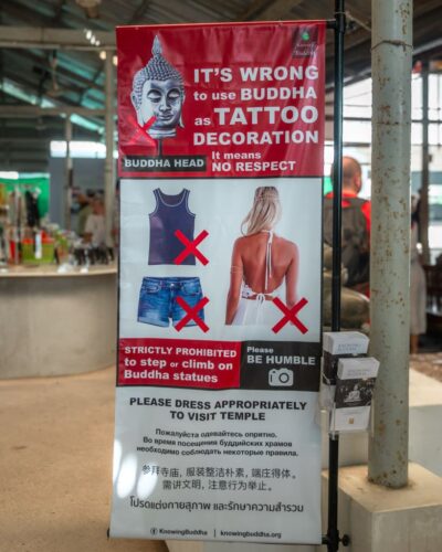 Banner med retninglinjer for (u)passende påklædning ved Big Buddha