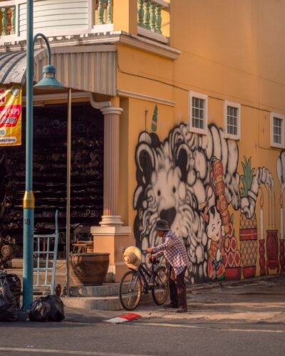 Ældre person på gaden i Phuket Old Town med street art
