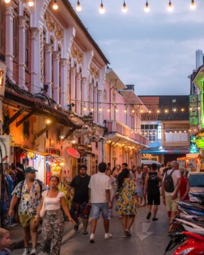 Soi Romanee i aftenlyset med turister på gaden