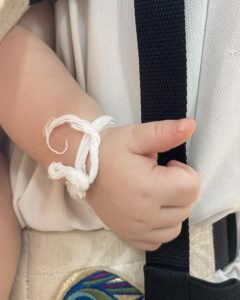 Babyhånd med bomuldssnor i Thailand