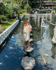 Victoria ved vandtempel med Adrian i bæresele, dækket for solen